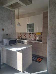 a kitchen with a counter top with a microwave at Luciane in Nettuno