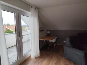 a living room with a desk and a large window at Ferienwohnung Beelen in Beelen