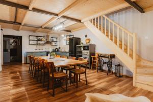 a kitchen and dining room with a wooden table and chairs at Chata Pekný les in Horné Hámre