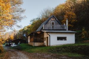 a small house with a balcony on top of it at Chata Pekný les in Horné Hámre