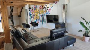 a living room with a leather couch and a television at Casa Rural El Pinche in Quincoces de Yuso