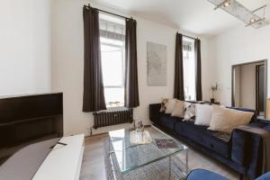 a living room with a couch and a glass table at Amazing warehouse conversion apartment in Chiswick in London