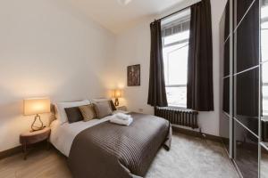 a bedroom with a bed and a large window at Amazing warehouse conversion apartment in Chiswick in London