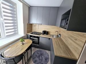 a small kitchen with a wooden table and a sink at Apartments in Bălţi