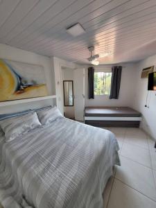 a bedroom with a bed and a bench in it at Confortável Apartamento em Maresias in São Sebastião +51 photos