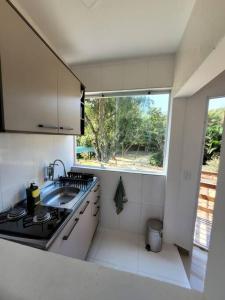 a small kitchen with a sink and a window at Confortável Apartamento em Maresias in São Sebastião