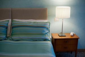 a bedroom with a bed with a lamp on a night stand at Garibaldi R&B in Messina