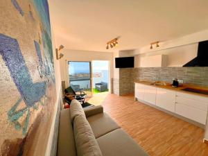a living room with a couch and a kitchen at Bungalow mit Meerblick und Gemeinschaftspool in Caleta De Fuste