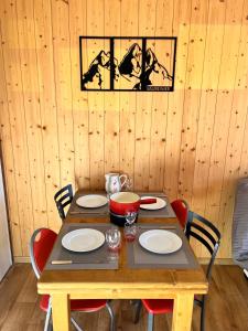 a wooden table with chairs and a wooden wall at Appartement 4 personnes au pied des pistes - GP1 in Valmeinier
