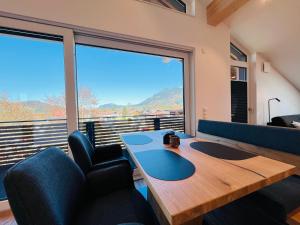 a room with a table and chairs and a large window at AlpSuites Oberstdorf in Oberstdorf