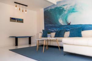 a living room with a white couch and a large painting at Villa Stars Seaview Corralejo in Corralejo
