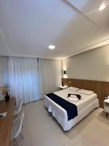 a hotel room with a large bed and a desk at Hotel Miguel Teixeira in João Câmara +6 photos