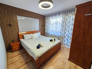 a bedroom with a bed with two pillows and a window at Prime Apartments in Bansko