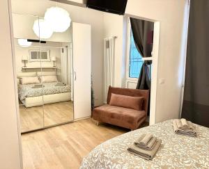 a bedroom with a mirror and a bed and a chair at Casa Sofia in Bologna