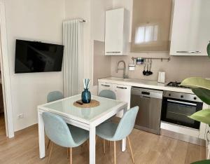 a kitchen with a white table and blue chairs at Casa Sofia in Bologna +10 photos