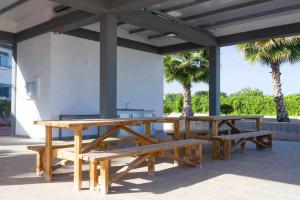 una mesa de picnic y bancos bajo un pabellón con palmeras en Bungalow Pink Oasis - Winter by the Sea, en Alicante