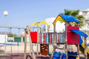 un patio de recreo con un tobogán en un parque en Bungalow Pink Oasis - Winter by the Sea, en Alicante