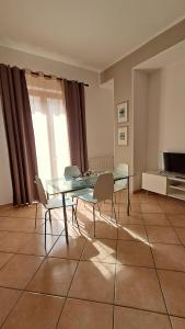 a dining room with a glass table and chairs at La Casa di Birba in Acquedolci