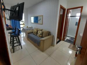 a living room with a couch and a flat screen tv at Apartamento aconchegante em ilheus in Ilhéus