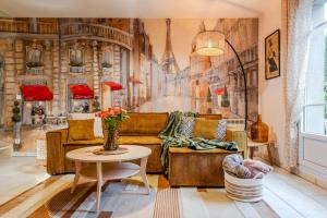 ein Wohnzimmer mit Sofa und Tisch in der Unterkunft Phantasia by Kleidos, 10 min de Disney! Jolie Maison Familiale 6P, 2 chambres, Terrasse, Parking in Magny-le-Hongre
