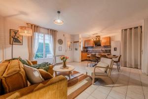 ein Wohnzimmer mit Sofa und Tisch in der Unterkunft Phantasia by Kleidos, 10 min de Disney! Jolie Maison Familiale 6P, 2 chambres, Terrasse, Parking in Magny-le-Hongre