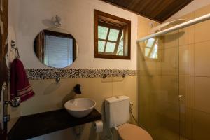 a bathroom with a toilet and a sink and a mirror at Vila Flor Eco Centro in Diogo