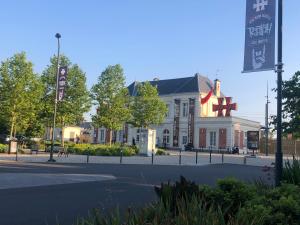 a large white building with a flag in front of it at Appartement touristique Clisson gare in Clisson