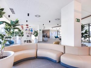 a waiting room with a couch and plants at Livensa Living Studios Madrid Alcobendas in Alcobendas +6 photos