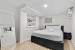a white bedroom with a large bed and a door at Spacious NW Apt Steps to 14th Street Corridor in Washington, D.C.