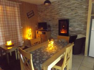 a living room with a dining table and a fireplace at Chalet Bastilor in La Joue du Loup