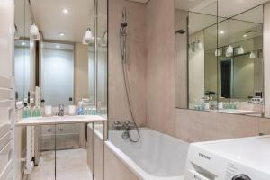 a bathroom with a tub and two sinks and a shower at Foch triomphe in Paris +21 photos