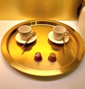 two cups and saucers on a gold plate with chocolates at Studio élégant Presqu'île Lyon 1er in Lyon