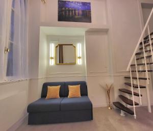 a living room with a blue couch and a mirror at Studio élégant Presqu'île Lyon 1er in Lyon