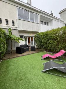 a house with a yard with pink items on the grass at Appart bain à remous et jardin proche plage l Eden in Calais +35 photos