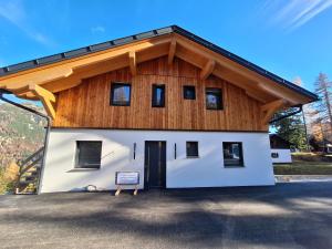 un grande edificio bianco con un tetto di legno di Almhaus Hochenwarter a Sonnenalpe Nassfeld