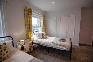 a small bedroom with two beds and a window at Winchester City House in Winchester