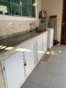 une cuisine avec un évier et un plan de travail dans l'établissement Casa aconchegante em Aquarius, à Cabo Frio