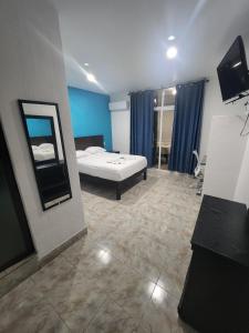 a large room with a bed and a mirror at Hotel Turquesa in Playa del Carmen