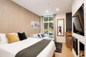 a bedroom with a bed and a flat screen tv at Cozy Cabin Vibes at Glacier Lodge in Whistler