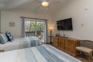 ein Schlafzimmer mit Bett und Flachbildfernseher in der Unterkunft Tiki 250 in South Padre Island