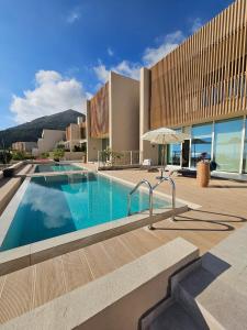 a large swimming pool in front of a building at Villa Champagne Green Coast Palase in Palasë