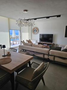 a living room with a couch and a table at Villa Champagne Green Coast Palase in Palasë +60 photos