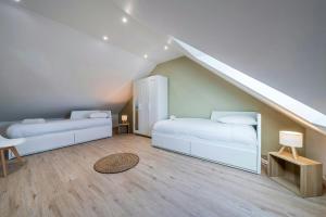 a attic bedroom with two beds and a staircase at The Comte House - 16 Guests Near Disney in Villeneuve-le-Comte