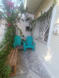 a porch with two blue chairs and a bench at Happy Accomation Houses 192mt to Harbour no6 in Marmaris