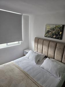 a bedroom with a bed with a large headboard at Apartaestudio FANTASTICO UBICADO EN EL NORTE DE ARMENIA CERCA A LOS PUEBLOS Y AL PARQUE DEL CAFE in Armenia +11 photos