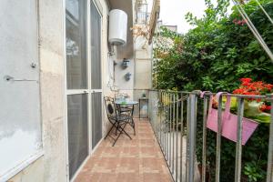 a balcony of a house with a table and a chair at La Dimora degli Attori in Catania