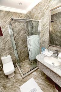 a bathroom with a shower and a toilet and a sink at Aquamarine Kuwait Resort(Families Only) in Al Nuwaiseeb