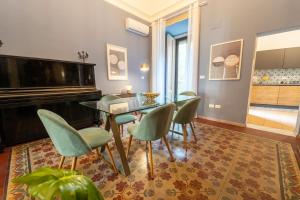 a dining room with a glass table and chairs and a piano at La Dimora degli Attori in Catania
