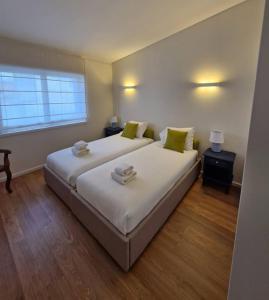 a bedroom with a large white bed with green pillows at Casa Francisca praia de Mindelo in Mindelo