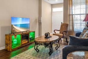 a living room with a tv and a coffee table at Mid-City Serenity in Huntsville